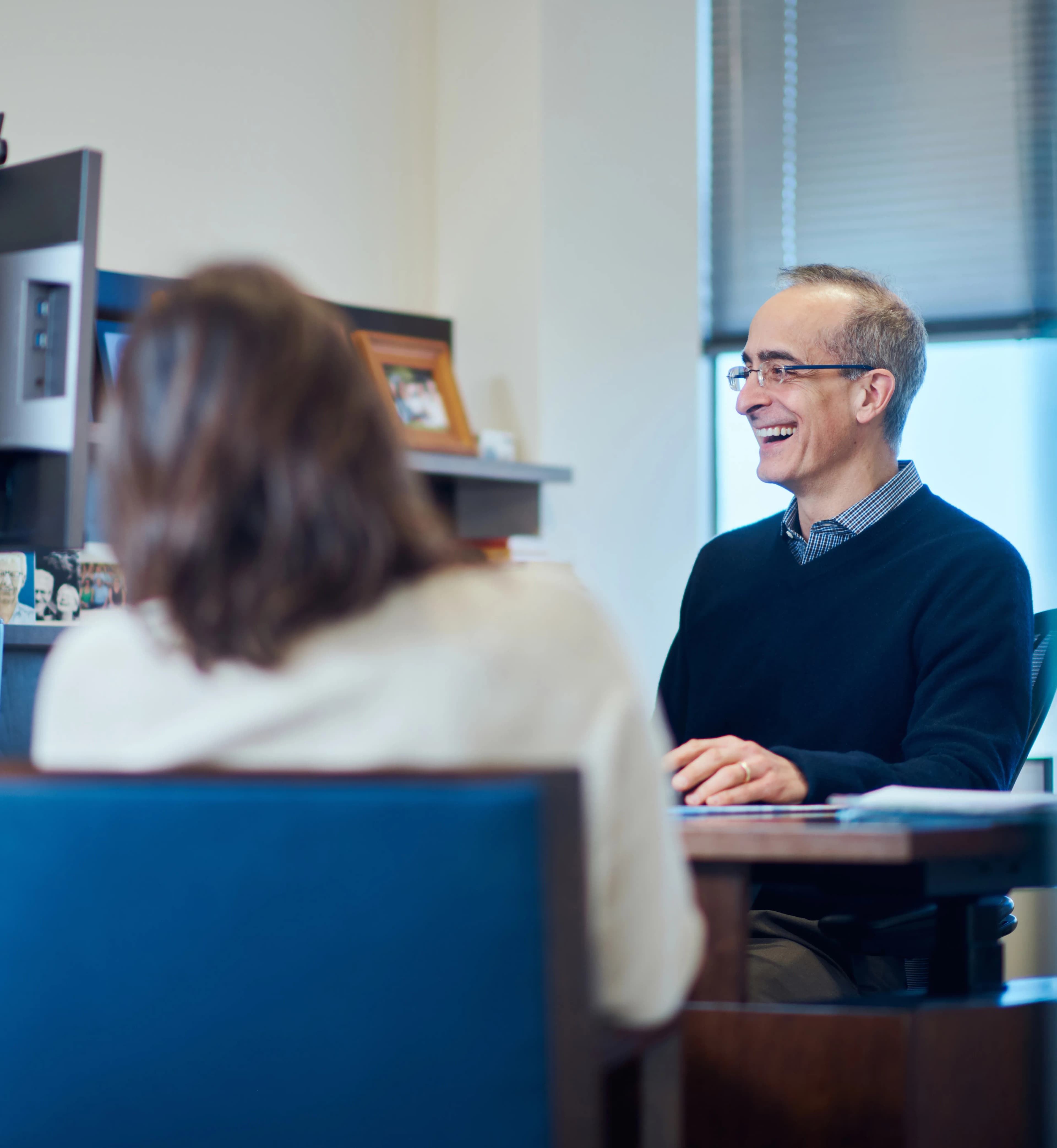 man at desk with woman laughing