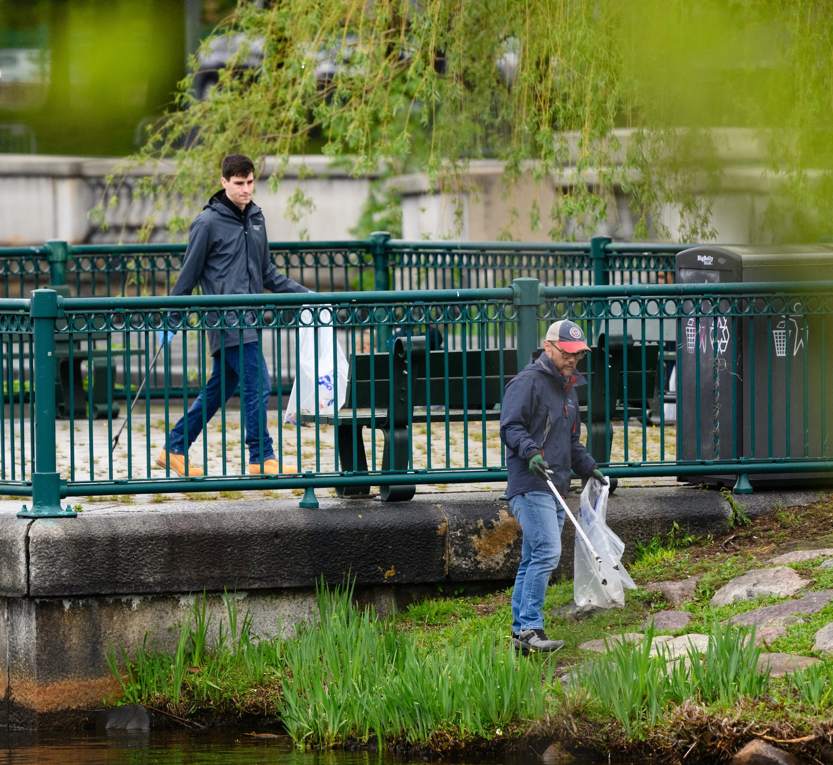 volunteers cleaning up trash around lake